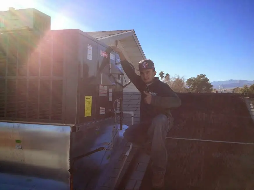 HVAC technician performing Heat Pump Repair on a rooftop unit in Hillview